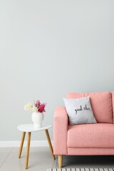 Pink sofa and table near light wall
