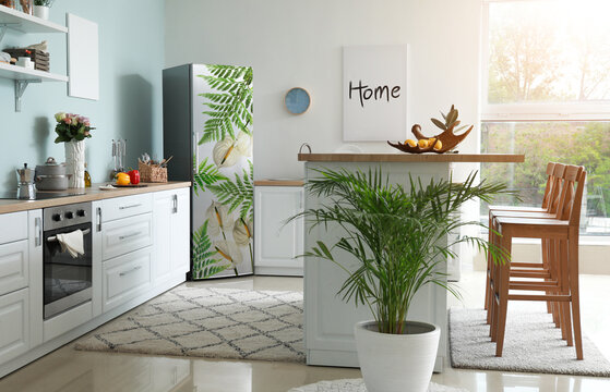 Refrigerator with print of tropical flowers and leaves in interior of modern kitchen