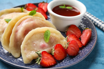 Plate with tasty strawberry dumplings and jam on color background, closeup