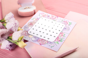 Wedding calendar and beautiful flowers on color wooden table, closeup