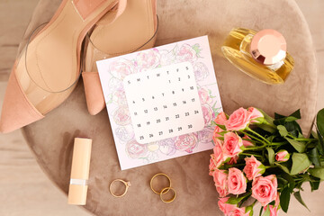 Wedding calendar, bridal accessories and beautiful flowers on pouf