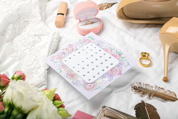 Wedding calendar, bouquet of flowers and bridal accessories on fabric background