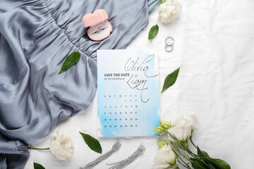 Wedding calendar and bridal accessories on white fabric background