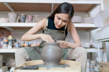 Close up of asian artist ceramist female hands working on potters wheel,asian female sculpture...