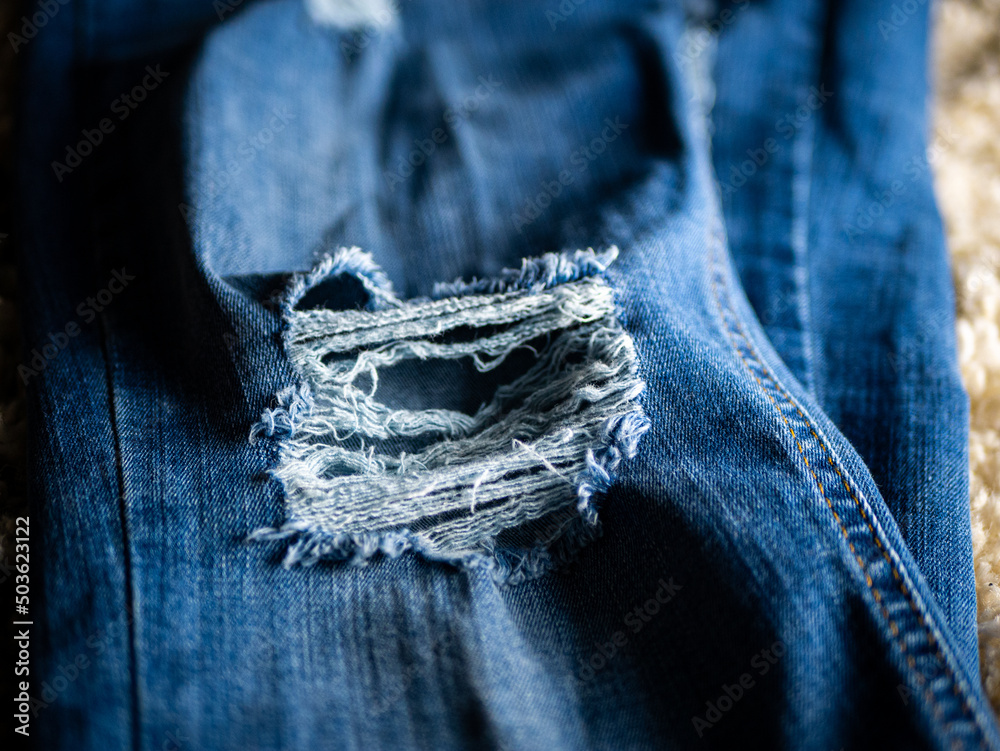 Canvas Prints Close-up shot of blue fashionable stylish faded ripped denim jeans texture