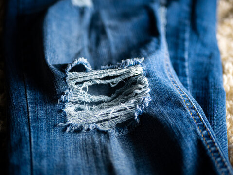 Close-up Shot Of Blue Fashionable Stylish Faded Ripped Denim Jeans Texture
