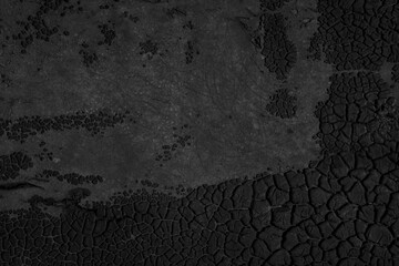 Black cracked texture background. Dark, beautiful, abstract pattern nature backdrop. Old, dry, deserted surface of tar, pitch, resin or soil. Eerie grooves and scratches. Close up, copy space