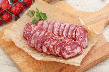 Sliced salami sausages over board