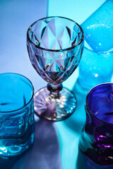 Stylish empty glasses on color background, closeup