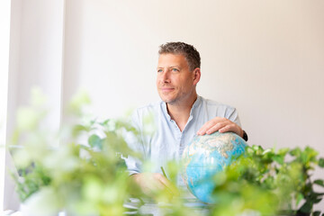 Business portrait of environmental engineer, ecologist, garden architect sitting at his work table...