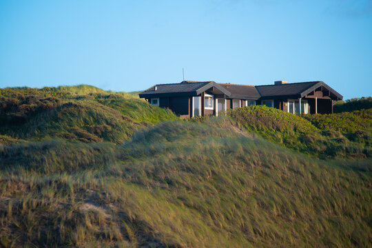 Exterior view of a summer house in Denmark near the North Sea under a blue sky