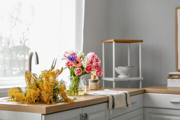 Beautiful blooming flowers in sink counter near window