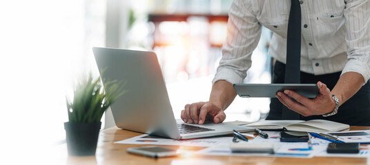 Businessman or accountant working Financial investment on laptop, calculate, analyze business and marketing growth on financial document data graph, Accounting, Economic, commercial concept.