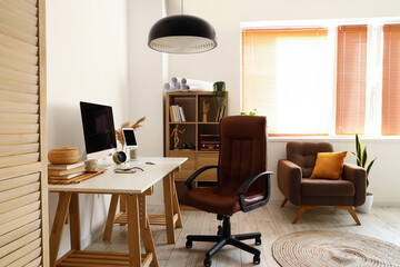Workplace with modern gadgets in light room interior