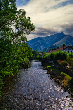 Half-timbered or baserri farmhouses of Saint-Etienne-de-Baigorry commune under a blue cloudy sky