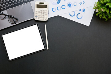 Modern business workspace table with tablet mockup and copy space on black background