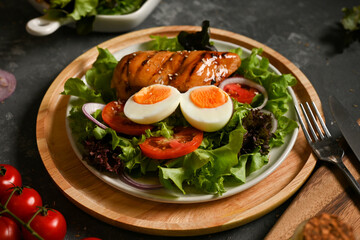 Tasty healthy salad with boiled egg and roasted grilled chicken breast