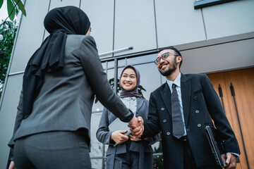 muslim business partner shaking hand at the office front during first meeting. business formal greeting