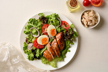 Grilled chicken fillet or chicken breast with boiled eggs and green vegetables salad