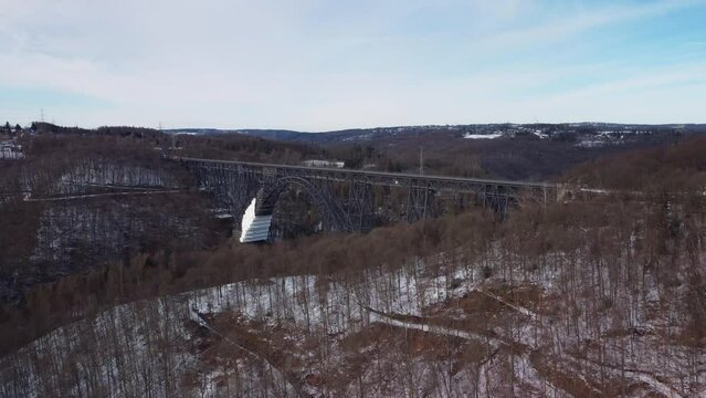 Mungestener Bridge, tourist attraction in Germany. Drone fly to old steel high railway bridge in river valley during winter time.