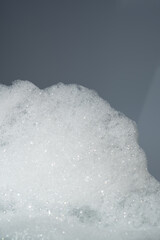 Fluffy white foam on a gray background.