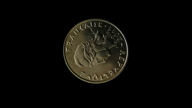 Rotating obverse of French Polynesia coin 20 francs 2011 with inscription meaning FRENCH REPUBLIC. Isolated in black background.