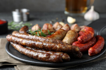 Set of different tasty snacks on dark grey table, closeup