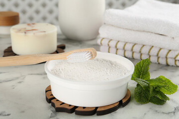 Tooth powder, brush and mint on white marble table, closeup