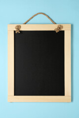 Clean small black chalkboard on light blue background, top view