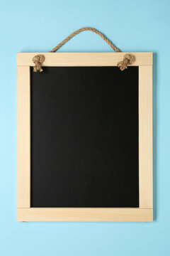 Clean small black chalkboard on light blue background, top view
