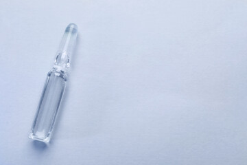 Pharmaceutical ampoule with medication on white background, top view. Space for text