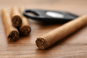 Many expensive cigars on wooden table, closeup