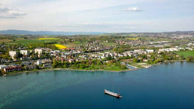 Flying Over The Panoramic View Of Preverenges Town In East Morges Facing Its Turquoise Waterfront In Vaud, Switzerland. Wide Aerial