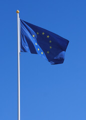 Flag of European Union on a flagpole at sky background. The waving  flag for your political concept about european integration and economic cooperation in Europe. - 503640719