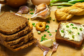 tasty lunch in rural style, healthy food - bread and butter sandwich, feta cheese, eggs, green leek and rye bread, cooked food on a white wooden boards