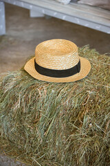 A beige hat lies on a haystack