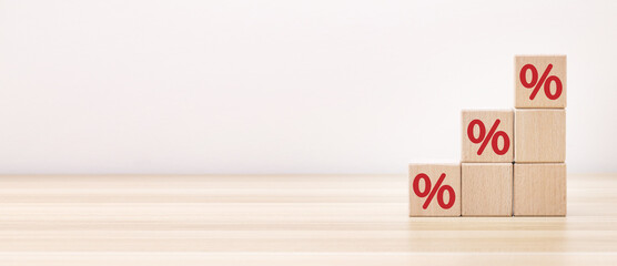 Interest rate financial and mortgage rates concept. Hand putting wood cube block increasing on top with icon percentage symbol upward direction. Panoramic image - obrazy, fototapety, plakaty