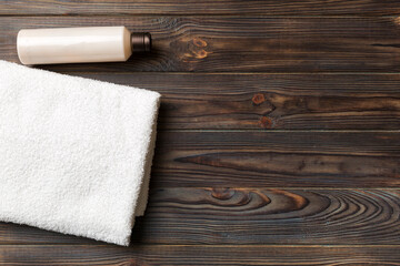 Cosmetic shampoo bottle mockup with towels on a colored table. Bathroom background, toilet accessories for hand and body care