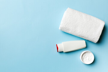 Fototapeta premium Cosmetic shampoo bottle mockup with towels on a colored table. Bathroom background, toilet accessories for hand and body care
