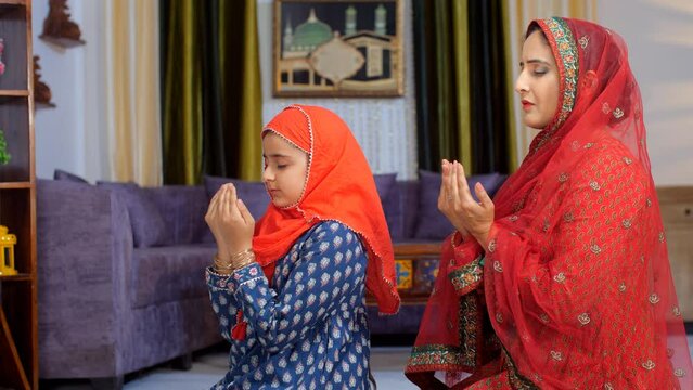 A Muslim Indian family - Mother and daughter offering prayers to the Almighty  ritual  faith belief. A middle-aged Indian housewife and her little daughter performing Namaz together - Islamic relig...