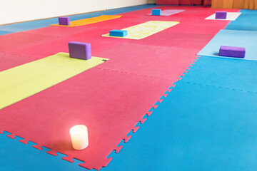 hall before yoga classes, yoga mats and yoga blocks in the gym, a candle on