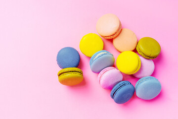 Fototapeta na wymiar French macarons dessert on a pink background, top view
