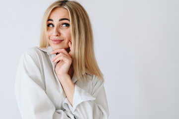 Girl with bags under her eyes looks up and to the side. Hand near the face on a white background.