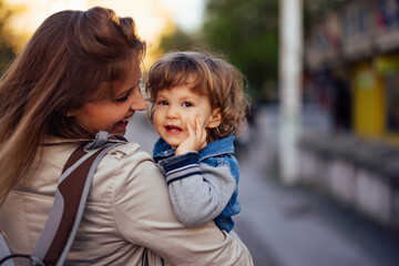 Fototapeta premium A smiling child laughing with his mom while being in a hug.