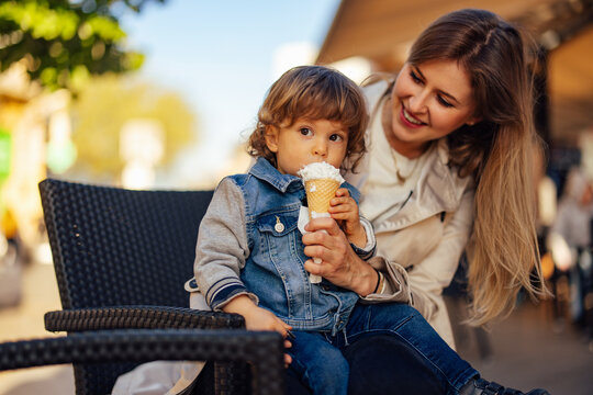 Single parent enjoying with her toddler, eating ice cream.
