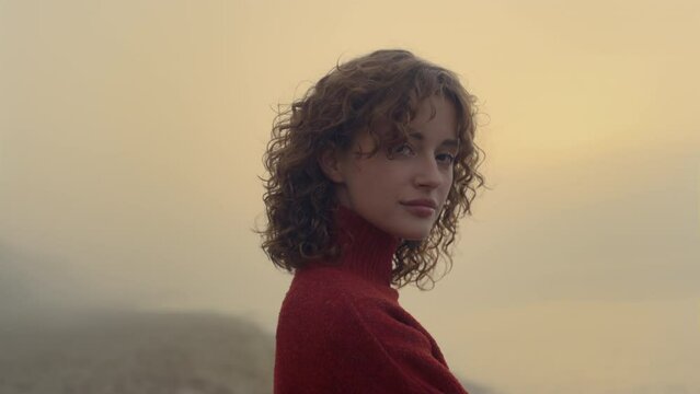 Sensual woman posing on beach in morning. Romantic girl smiling on camera