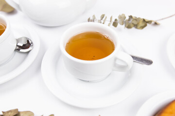 white porcelain cup with tea for tomorrow on the table with a saucer