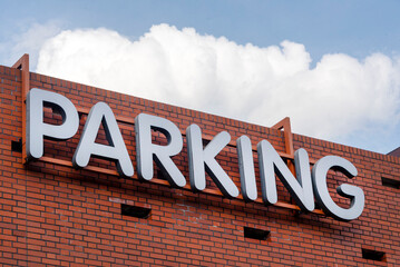 Entrance to the parking building. Word "PARKING" on the wall, parking sign.