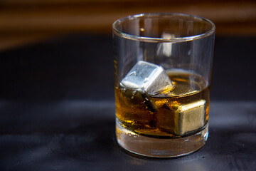 Glass of whiskey eith metal ice cubes