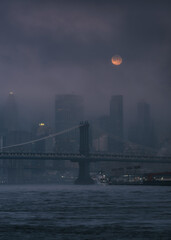 Full moon over the financial district on a foggy morning